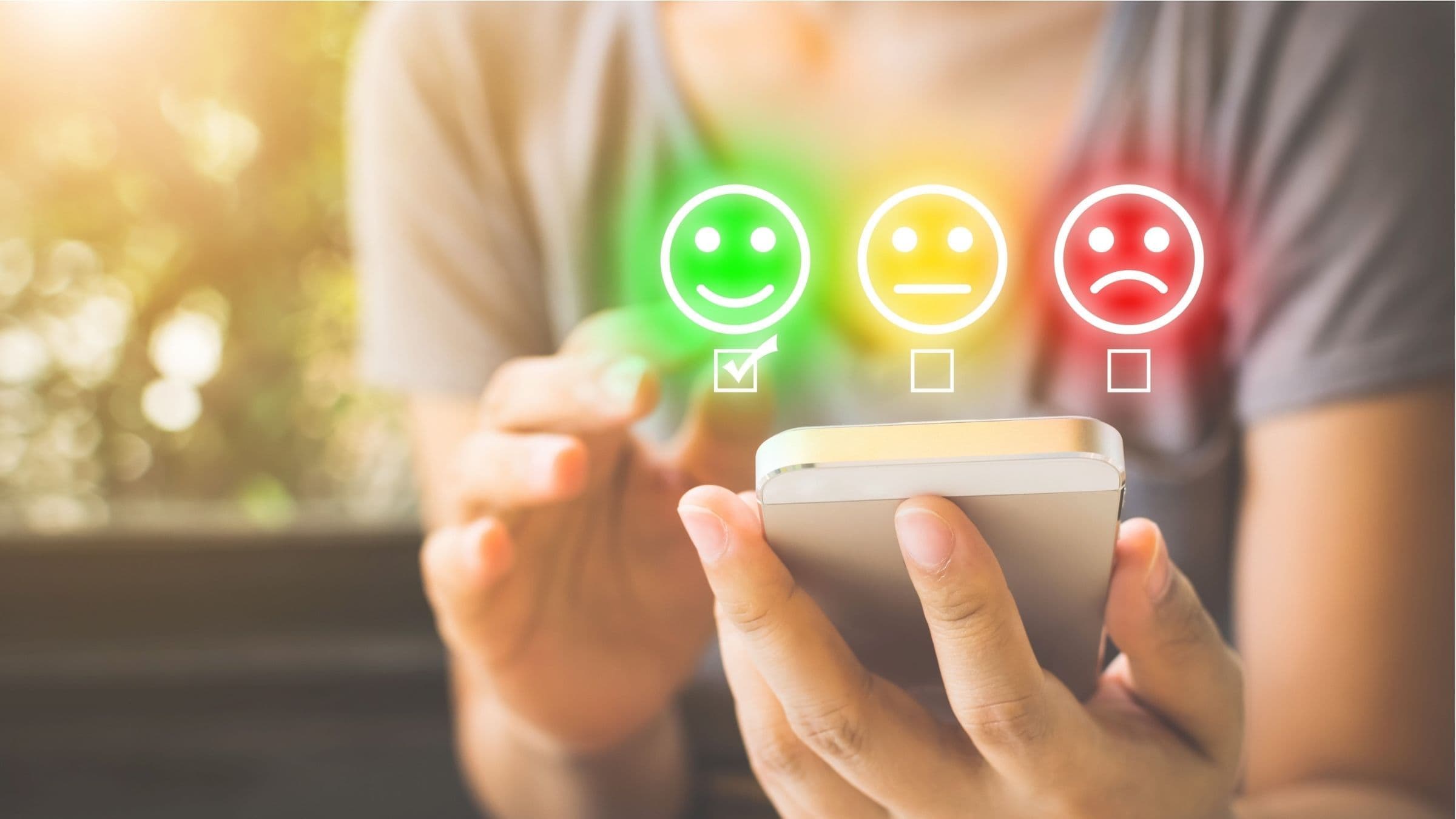 Persona utilizza uno smartphone con icone colorate per esprimere la soddisfazione del cliente.